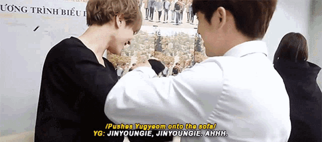 two men are standing next to each other and one of them says pushee yugyeom onto the sofa