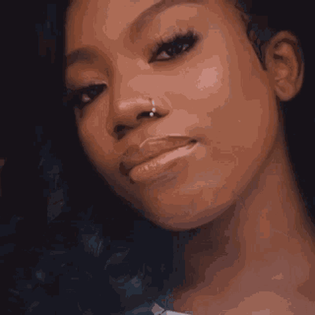 a woman with a nose ring and a white shirt