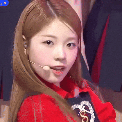 a close up of a woman wearing a red shirt and a microphone in her mouth .