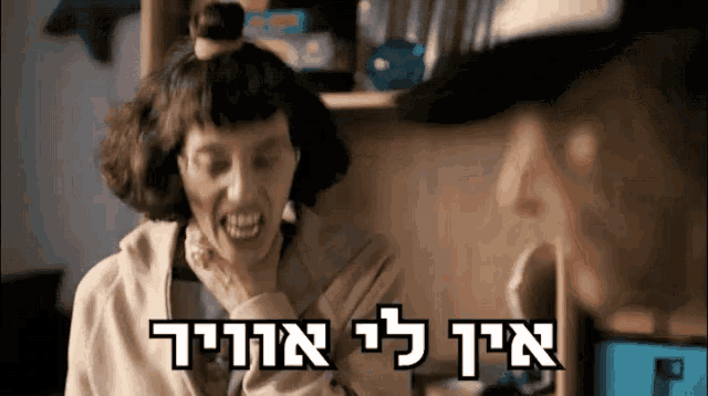 a woman with a bun on her head is smiling with the words " אין לי אויר " written below her