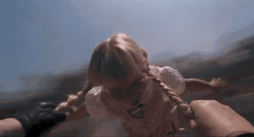 a person is holding a little girl in their arms while she is falling into the water .