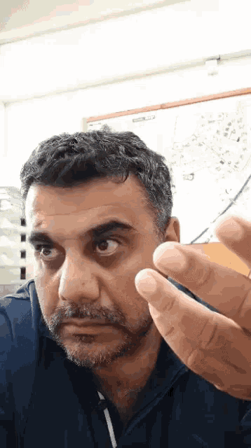 a man with a beard is making a funny face with his finger