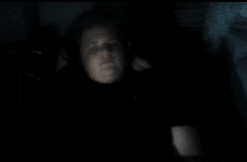 a blurry picture of a person 's face in a dark room