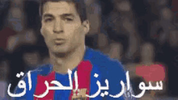 a soccer player with arabic writing on his jersey