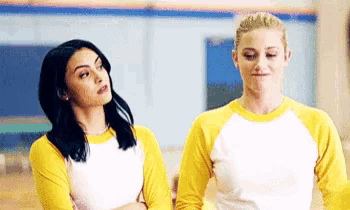 two women standing next to each other wearing yellow shirts