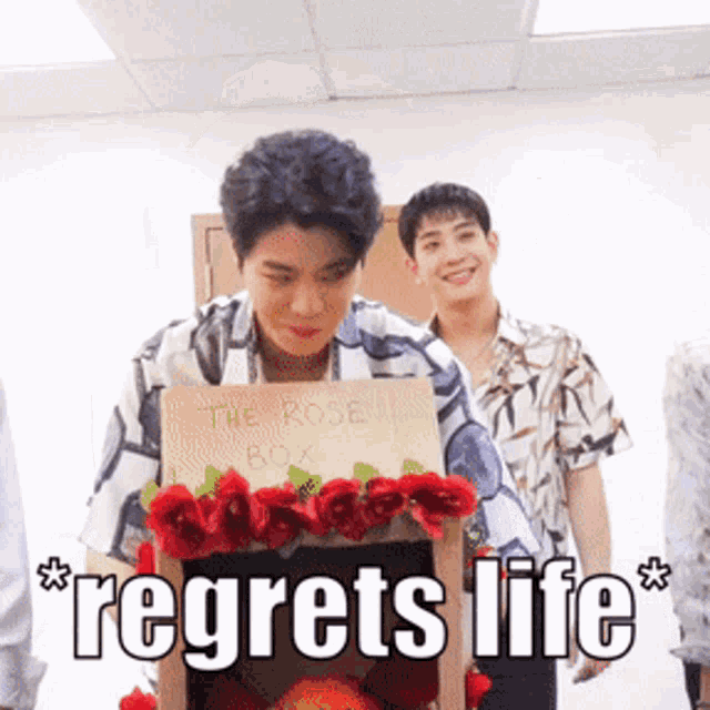 a man holding a sign that says the rose box regrets life