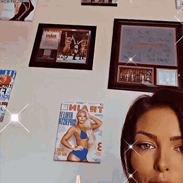 a woman in a bikini is standing in front of a wall with pictures and a magazine that says mia fit