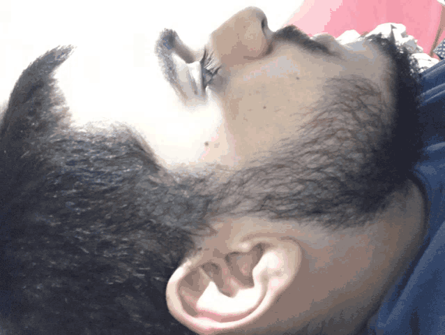a close up of a man 's ear and head with his eyes closed