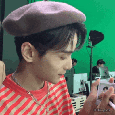 a young man wearing a purple beret and a red and white striped shirt