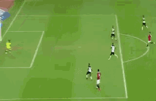 a soccer player with the number 14 on his back is standing on the field