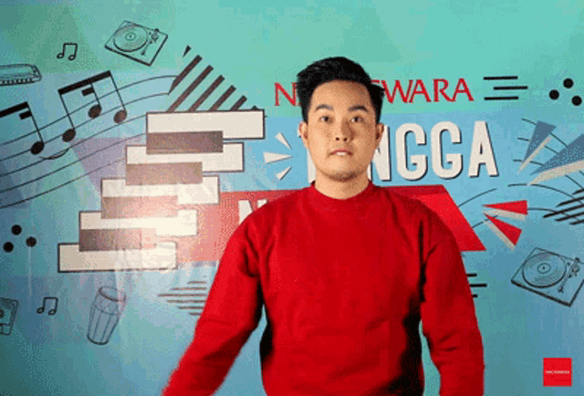 a man in a red sweater stands in front of a wall that says ncga