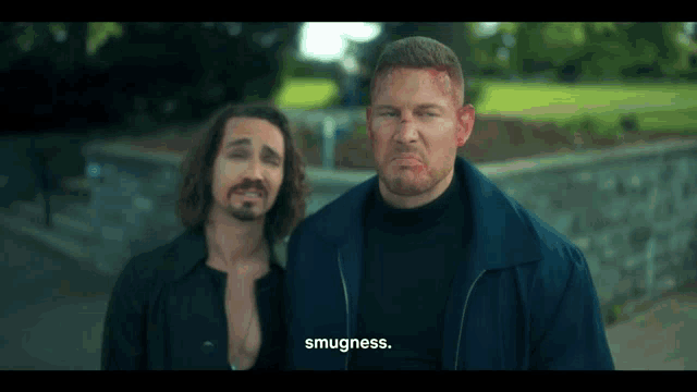 two men are standing next to each other and one of them says " smugness "