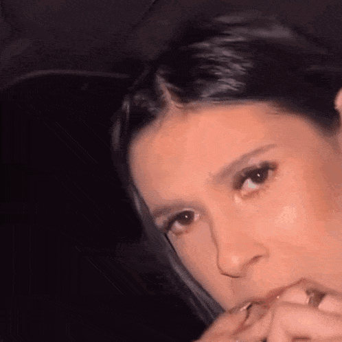 a woman is smoking a cigarette in a car .