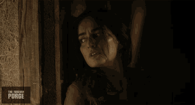 a poster for the forever purge shows a woman looking out of a window