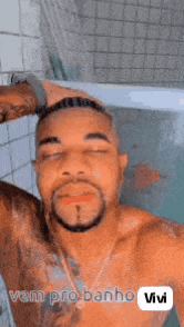 a shirtless man is taking a selfie in a bathtub