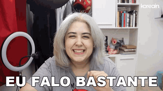 a woman with gray hair is smiling and says eu falo bastante