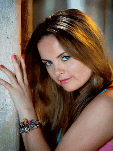 a woman with red nails and a bracelet on her wrist