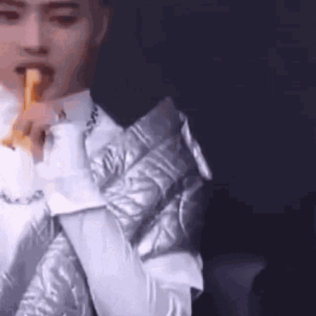a man in a suit is eating a banana while sitting on a couch .