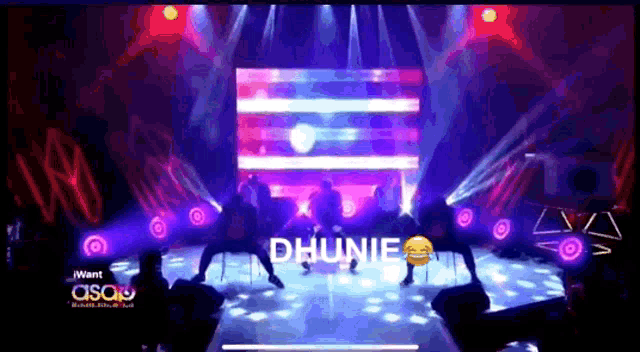 a group of people are dancing on a stage with the word dhuniie on it