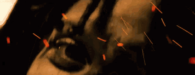 a close up of a woman 's face with fire sparks coming out of it .