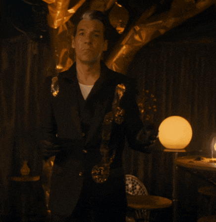 a man in a black suit holding a saxophone