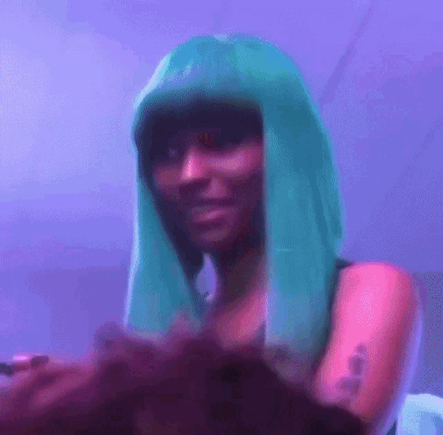 a woman wearing a green wig and a tattoo on her arm is standing in front of a purple wall .