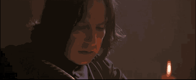 a man in a dark room with a candle lit in front of him