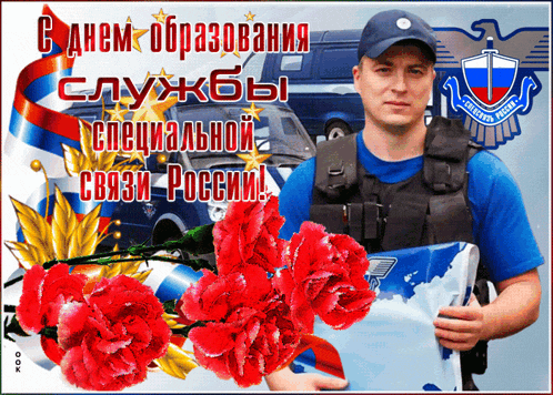 a man in a blue shirt is holding a laptop in front of flowers and a russian flag
