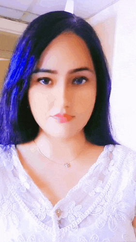 a woman with blue hair is wearing a white top and necklace