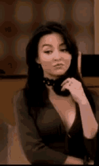 a woman in a plunging neckline is sitting in a chair .