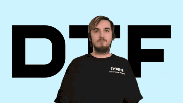 a man in a black shirt stands in front of a large d and f