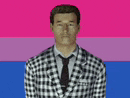 a man wearing a plaid suit and tie is standing in front of a bisexual flag .