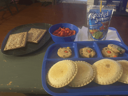 a bag of kool aid jammies sits on a table next to a tray of food