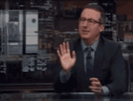 a man in a suit and tie is talking in front of a sign that says " first fuck "