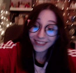 a woman wearing glasses and a red jacket smiles