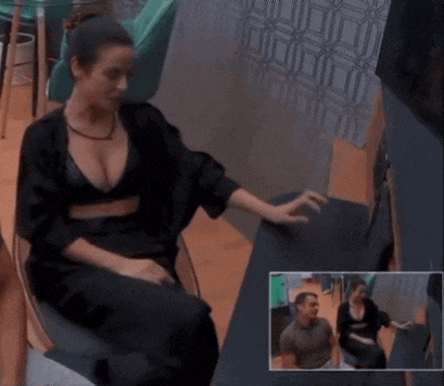 a woman in a black bra sits in a chair