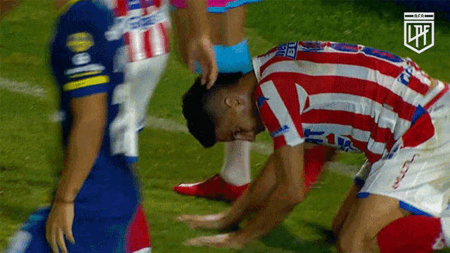 a soccer player wearing a red white and blue jersey with the number 11 on it kneels on the field