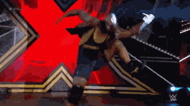 a wrestler is holding a marshmallow in front of a red and black background
