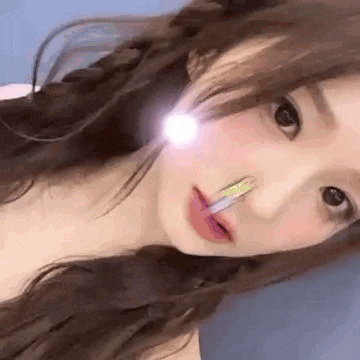 a close up of a woman 's face with a light shining on her face .