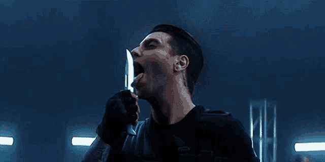 a man is holding a knife in his mouth and screaming .