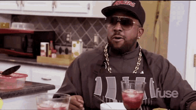 a man in a kitchen wearing an apron that says " fuse " on it