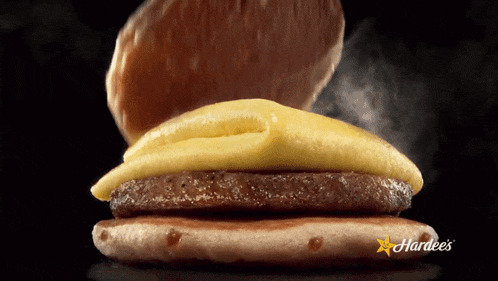 a hardee 's breakfast sandwich with eggs and cheese on a bun