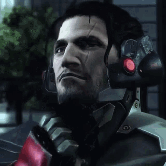 a close up of a man 's face with a red button on his head