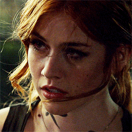 a close up of a woman 's face with a tattoo on her neck
