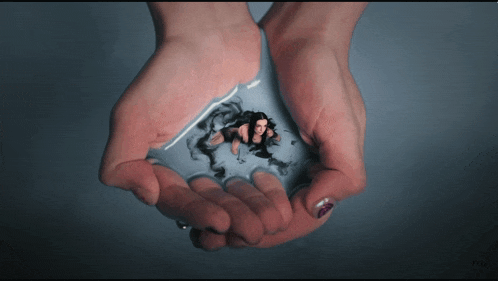 a woman holding a tiny woman in her hands