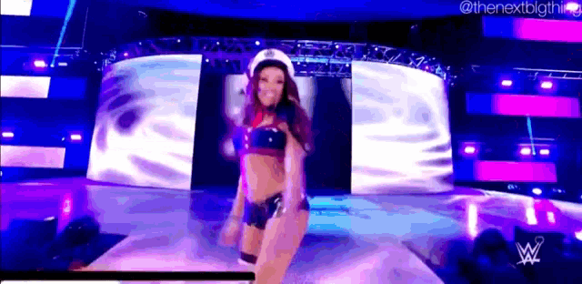 a woman in a bikini is dancing on a stage while wearing a hat .