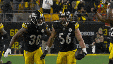 a football player with the number 56 on his jersey holds a football