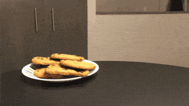 a plate of cookies on a table in front of a cabinet