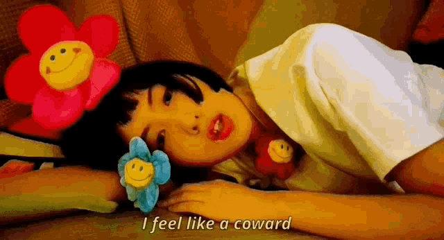 a girl laying on the floor with stuffed flowers on her head and the words i feel like a coward