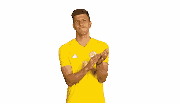 a man in a yellow shirt is clapping his hands together .